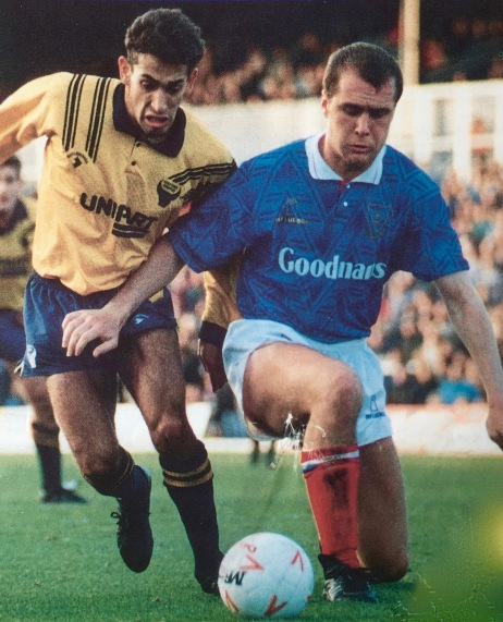 A programme cover shows Butts in action for Pompey v Oxford.